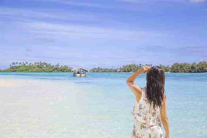 Girl standing over beautiful pristine postcardesque paradise water on Muri Moto
