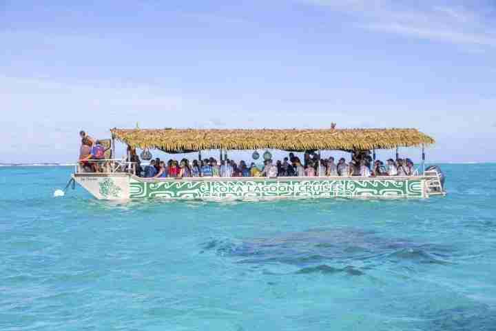 Koka Lagoon Cruises Boat over crystal clear water with reef visible underwater