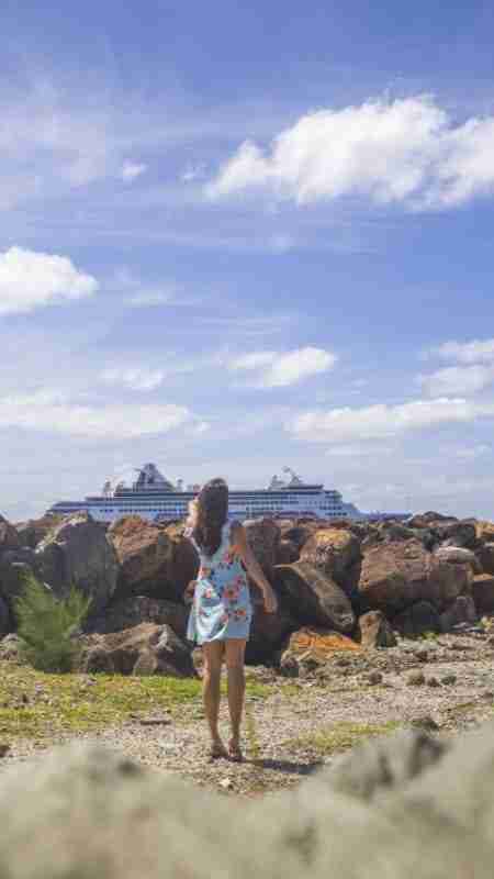 Girl pointing at giant cruise ship at Rarotonga Port