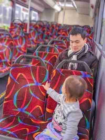 toddler and daddy sitting on airport shuttle