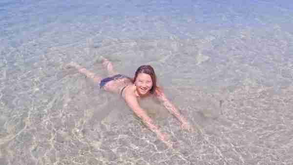 My top secrets to happiness travel success stay present carefree free spirit happy girl lying in crystal clear beach water in Fiji