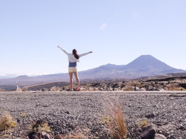 girl walking on road with mountain in the background
