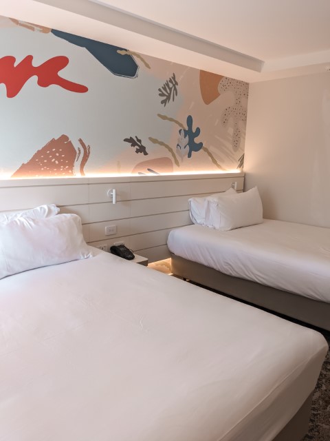 A spacious double room at Sea World Resort, Gold Coast, showcasing comfortable beds and modern decor, ready to welcome a family for a thrilling theme park adventure in Australia