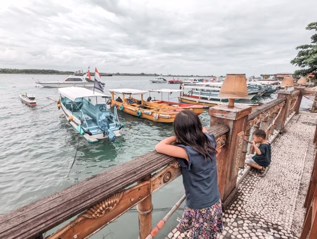 girl watching boats at the harbour in Pantura Tanjung Benoa, Bali Indonesia