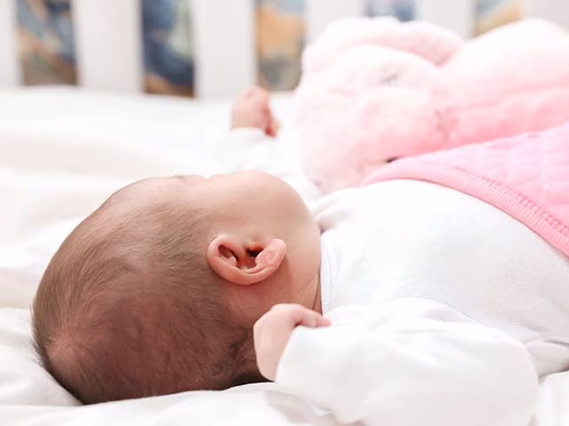 Baby sleeping with lovey bunny and pink blanket