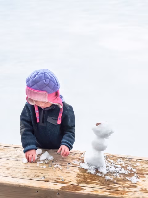Child building a snowman at Mt Ruapehu Sky Waka Family Kids Top Attraction Snowman Whakapapa Travel Blog New Zealand Kida