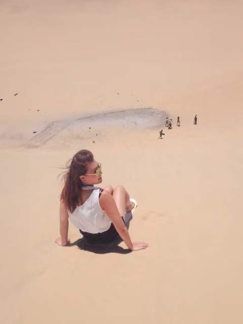 Family sandboarding at Anna Bay, Port Stephens on a Sydney to Brisbane road trip, east coast of Australia.