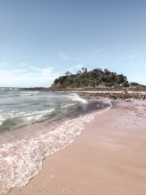 Seal Rocks beautiful beach and sea landscape with mountain backdrop.