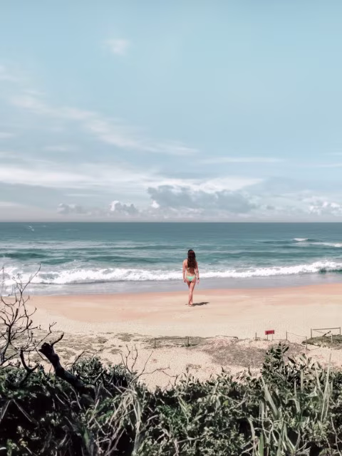 Family enjoying a beach on the east coast of Australia during their Sydney to Brisbane road trip, highlighting must-stop destinations.