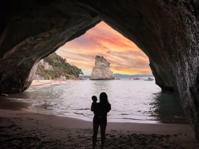 Coromandel Cathedral Cove family looking out to rock over crystal clear water at sunset