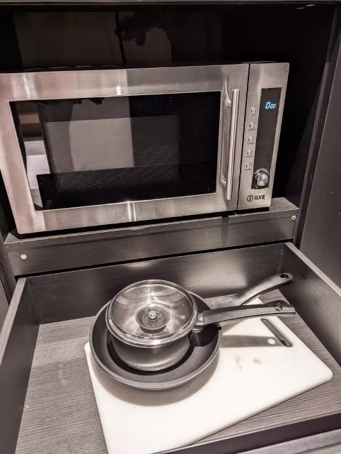 Microwave, pots pans and chopping board