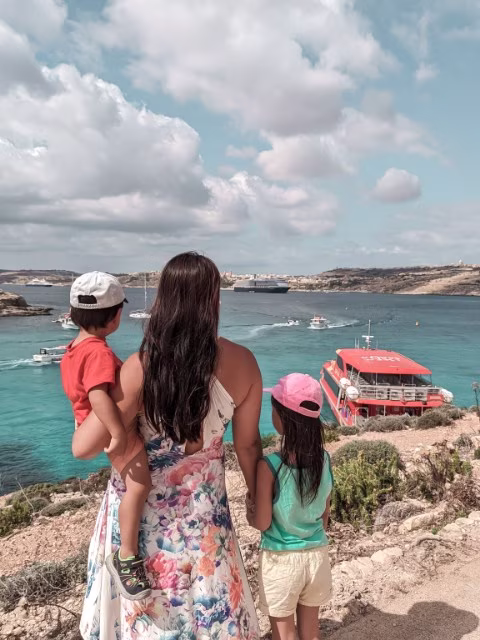 mother with two children looking over the crystal clear water in Malta on vacation holiday financial freedom mindset guide money wealth mentality change goals