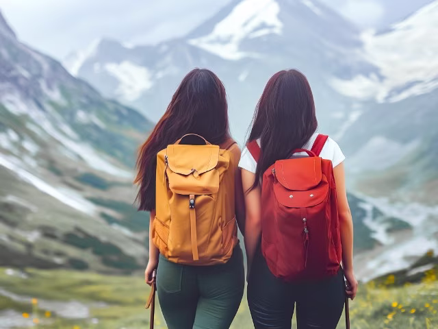 two woman hiking the mountains wearing backpacks, lift others success mindset rich habits to adopt wealth money financial freedom